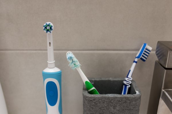 oral b toothbrush beside manual toothbrushes